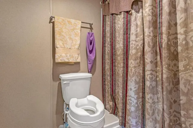 a white toilet sitting next to a shower curtain
