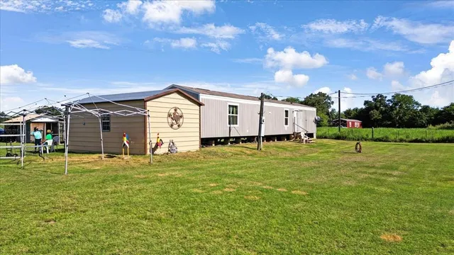 a large white house with a big yard and large trees