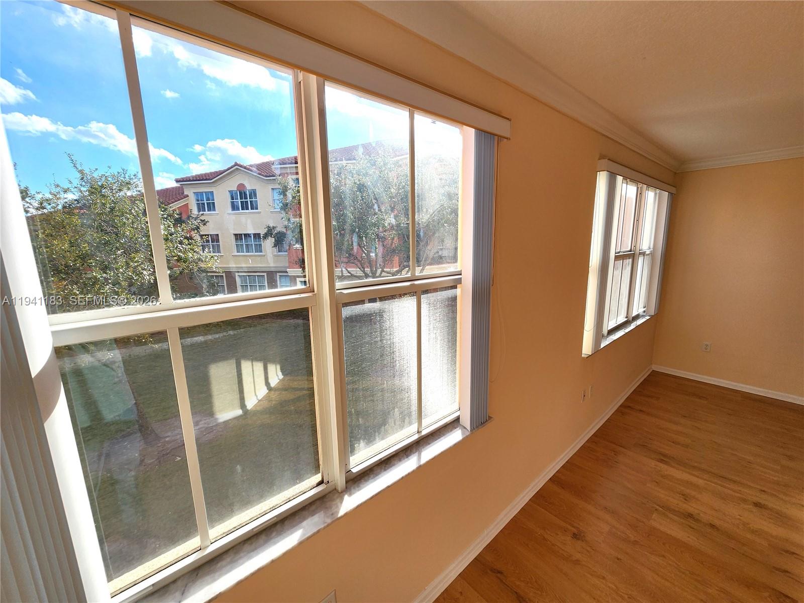 4602 Southwest 160th Avenue, Unit 524 Miramar, FL 33027 - Photo 13 of 33 a view of an empty room with wooden floor and windows