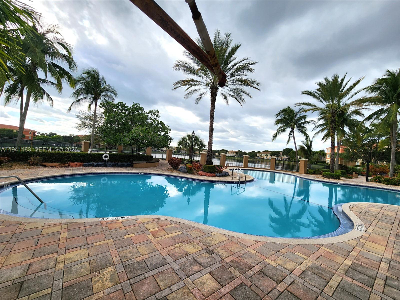 4602 Southwest 160th Avenue, Unit 524 Miramar, FL 33027 - Photo 26 of 33 a view of a swimming pool with a lounge chair and palm trees