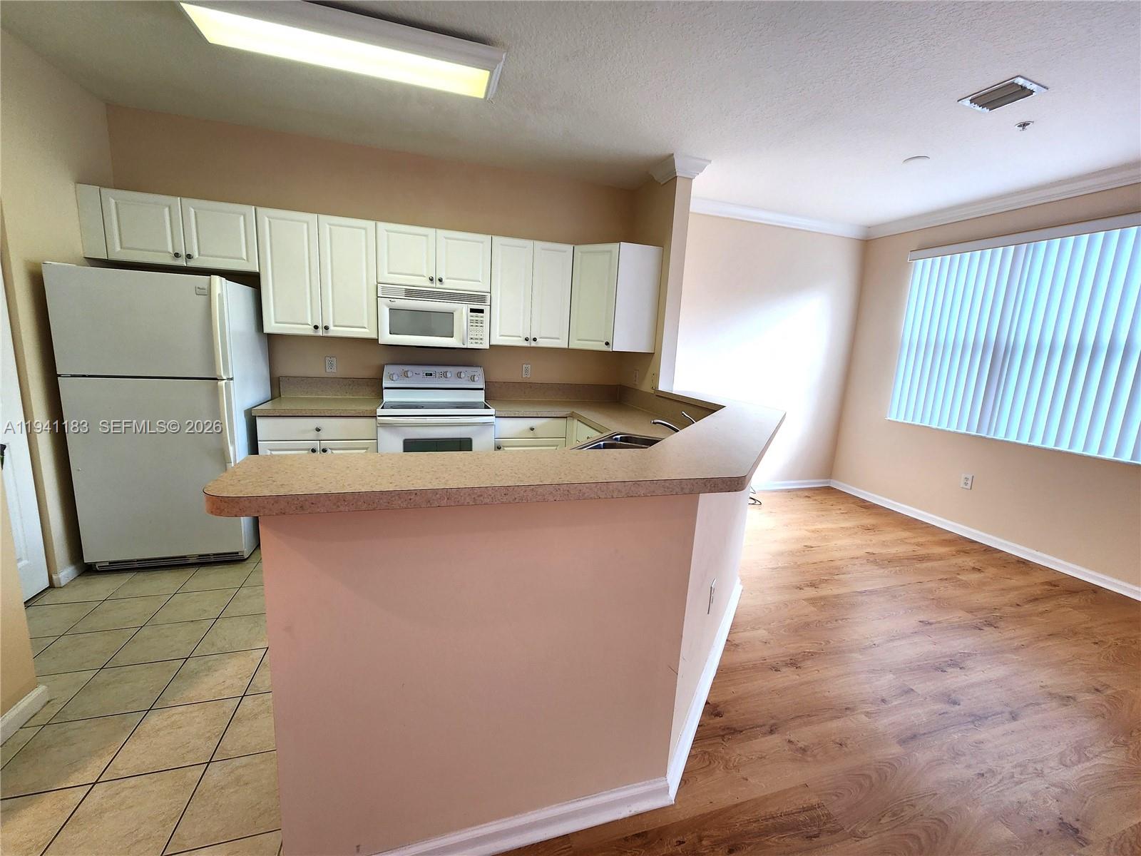 4602 Southwest 160th Avenue, Unit 524 Miramar, FL 33027 - Photo 6 of 33 a kitchen with kitchen island granite countertop a sink a counter top space and cabinets