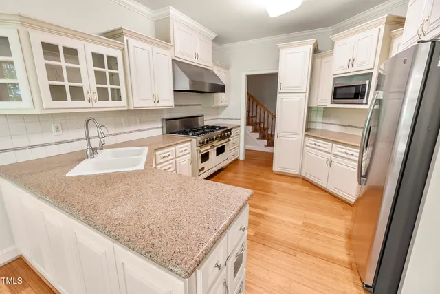 a kitchen with stainless steel appliances granite countertop a sink stove and refrigerator