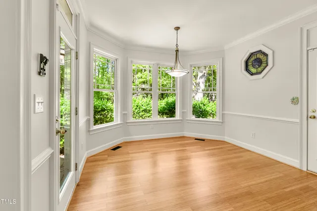a view of an empty room with window wooden floor and front door
