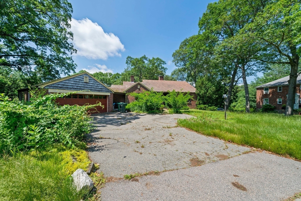 335 Langley Road Newton, MA 02459 - Photo 10 of 15 a front view of a house with a yard and garage