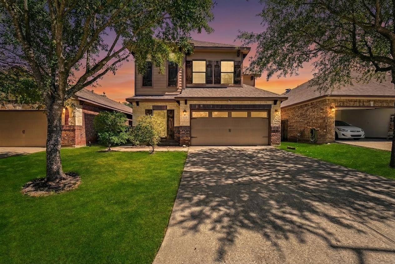 a front view of a house with a garden and yard