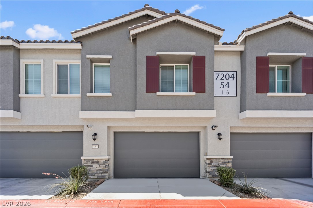 7204 North Decatur Boulevard, Unit 5 North Las Vegas, NV 89084 - Photo 29 of 34 Clean lines and stone accents define this modern multi-level exterior featuring integrated garage parking.