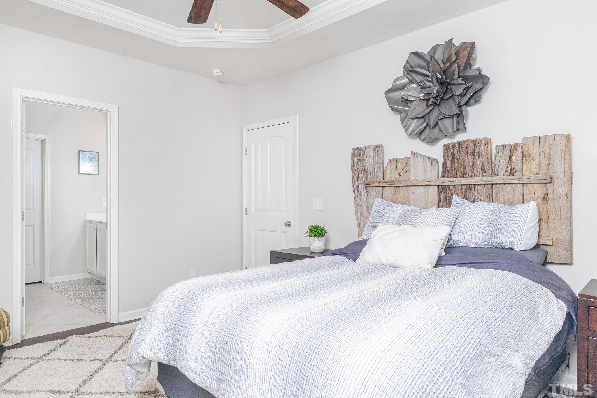 219 Torpoint Road Durham, NC 27703 - Photo 23 of 43 a bedroom with a bed and a painting on the wall