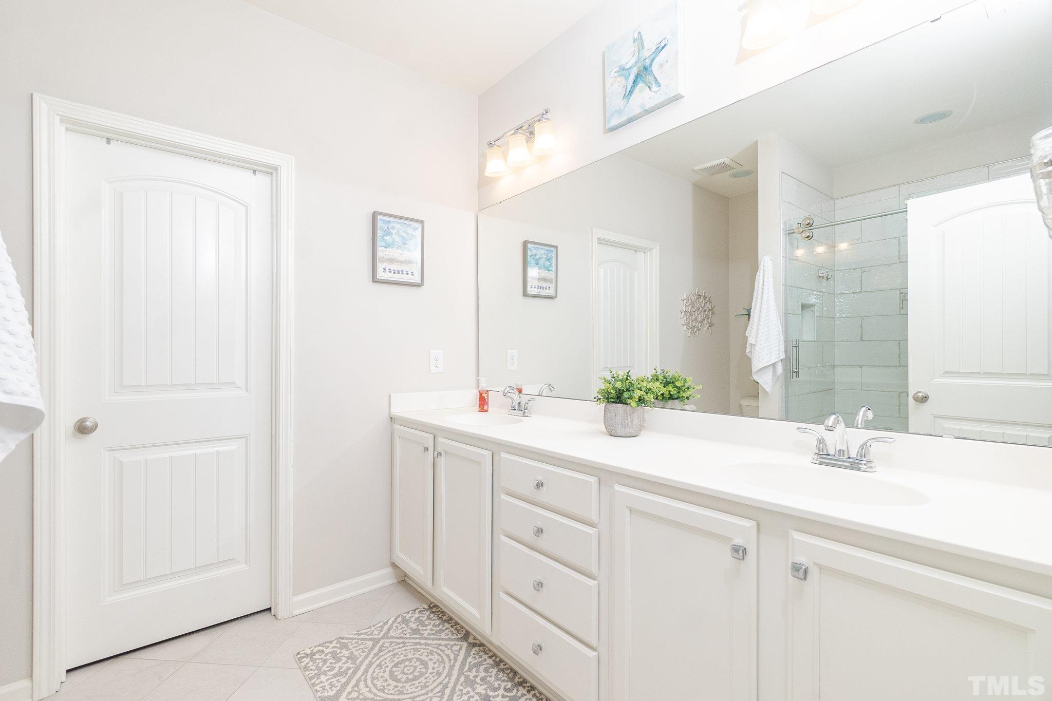 219 Torpoint Road Durham, NC 27703 - Photo 24 of 43 a bathroom with a double vanity sink mirror and next to a white cabinet