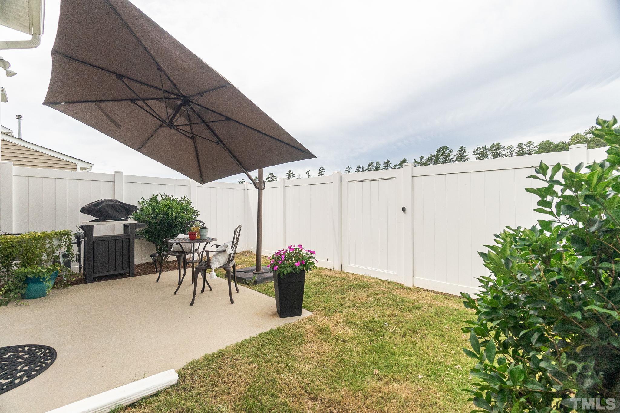 219 Torpoint Road Durham, NC 27703 - Photo 37 of 43 a view of a patio with table and chairs under an umbrella