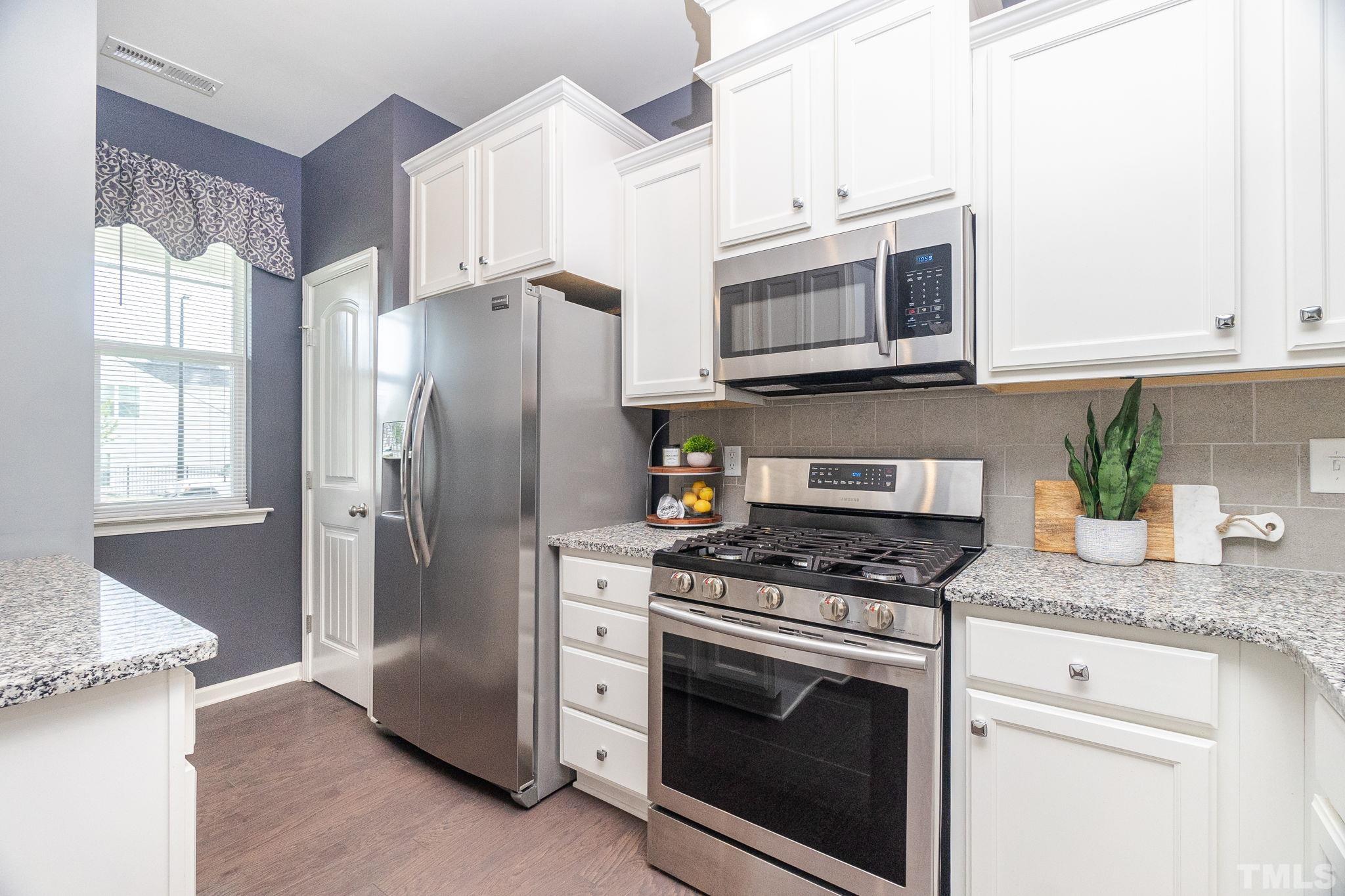 219 Torpoint Road Durham, NC 27703 - Photo 4 of 43 a kitchen with stainless steel appliances granite countertop white cabinets a refrigerator and a stove