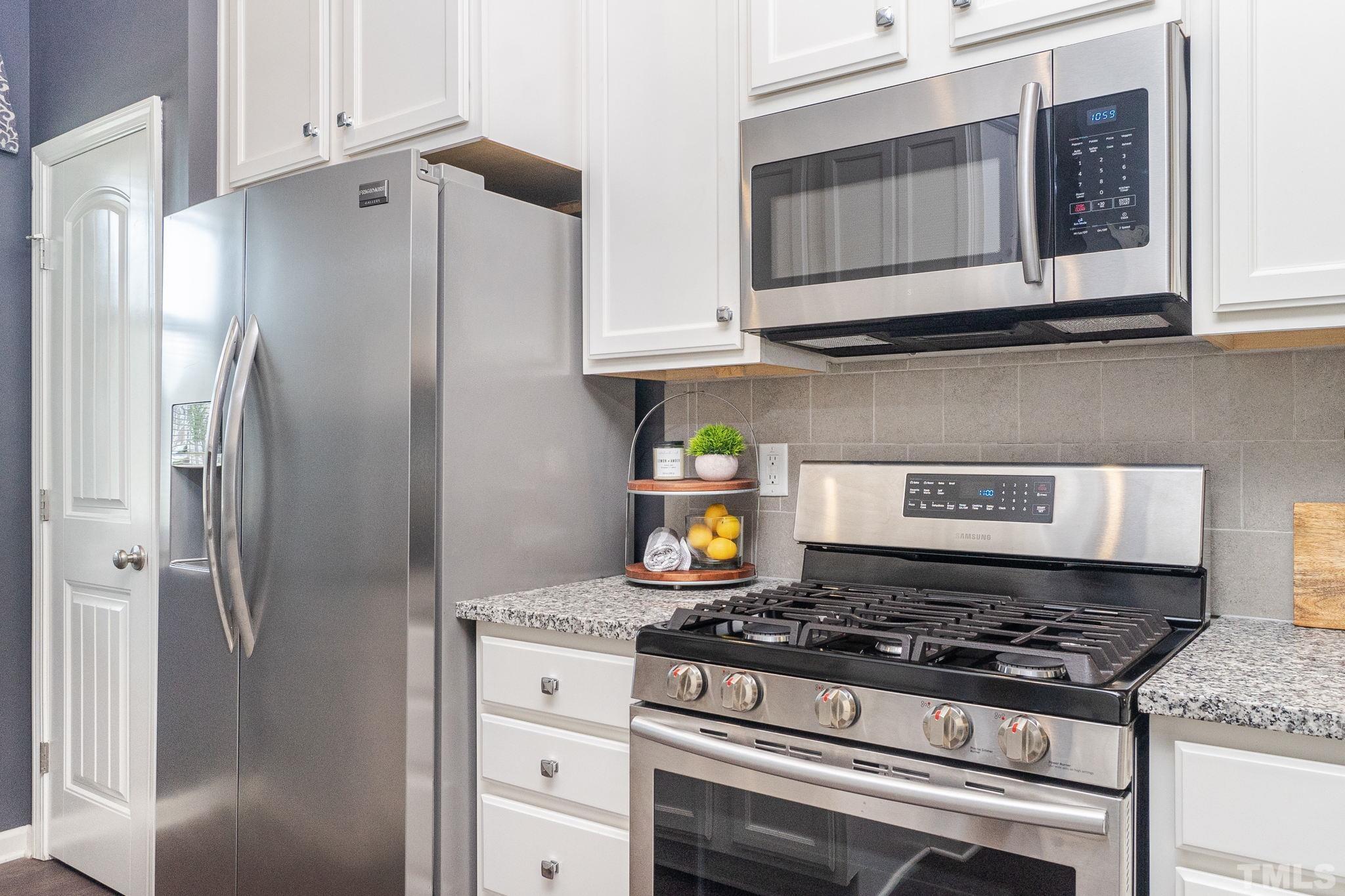 219 Torpoint Road Durham, NC 27703 - Photo 5 of 43 a kitchen with stainless steel appliances granite countertop a stove and a refrigerator