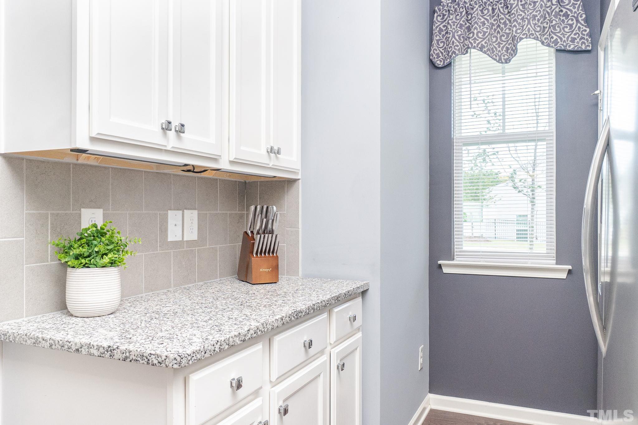 219 Torpoint Road Durham, NC 27703 - Photo 7 of 43 a kitchen with a granite countertop sink white cabinets and a window