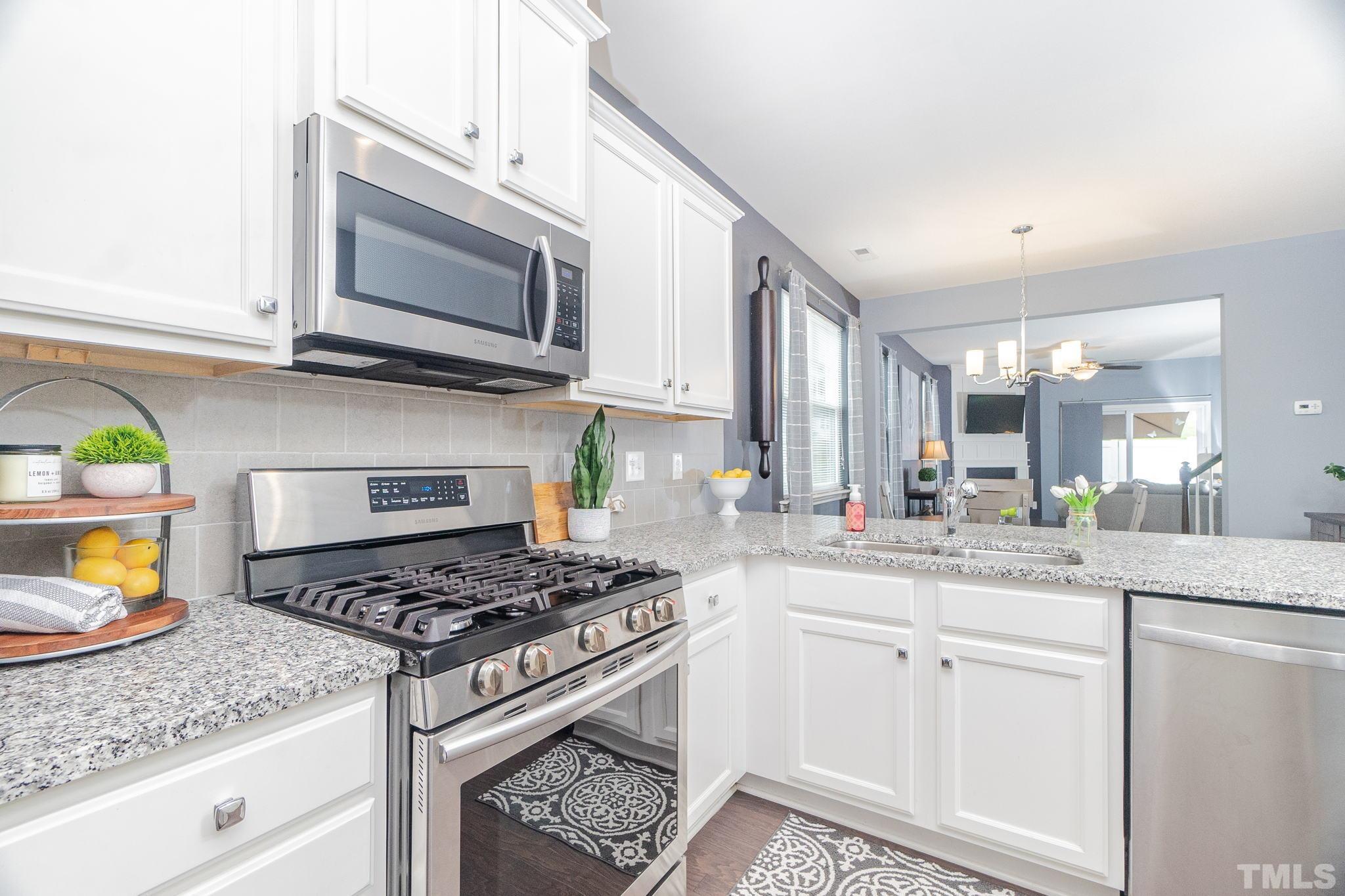 219 Torpoint Road Durham, NC 27703 - Photo 8 of 43 a kitchen with stainless steel appliances granite countertop a stove a sink and a microwave