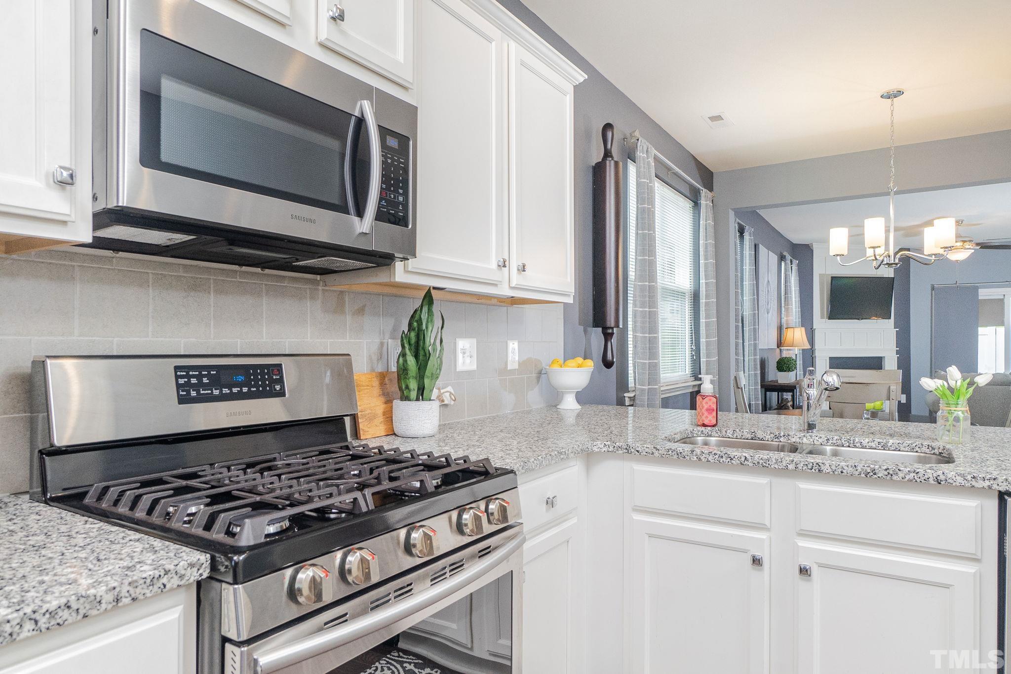 219 Torpoint Road Durham, NC 27703 - Photo 9 of 43 a kitchen with stainless steel appliances granite countertop a stove and a microwave
