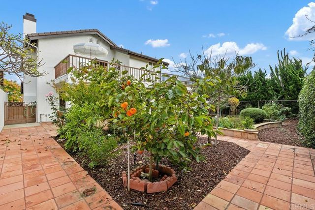 a front view of a house with a yard and potted plants