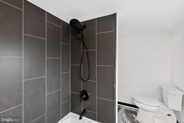 a bathroom with a toilet and a shower