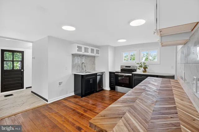 a kitchen with stainless steel appliances kitchen island granite countertop a refrigerator sink and cabinets