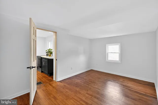 an empty room with wooden floor and a window
