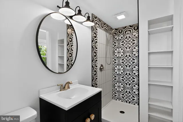 a bathroom with a sink a toilet and a mirror