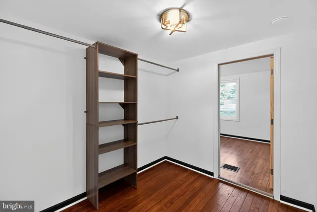 an empty room with wooden floor and closet