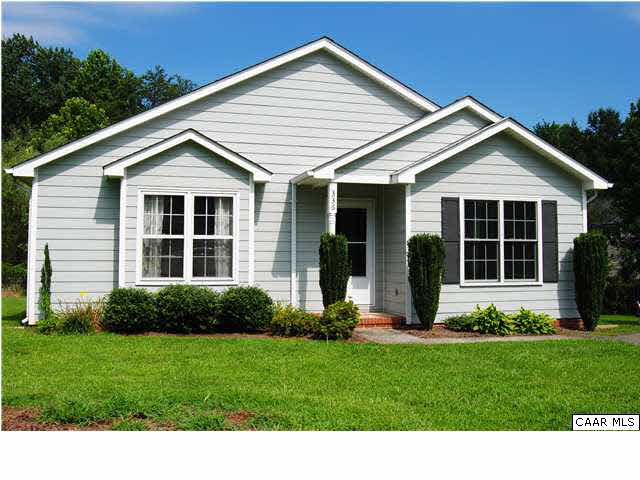 a front view of a house with a yard and green space