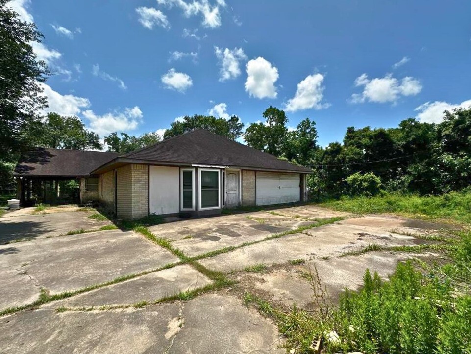 1225 County Road 878B Sweeny, TX 77480 - Photo 2 of 9 a backyard of a house with table and chairs under an umbrella