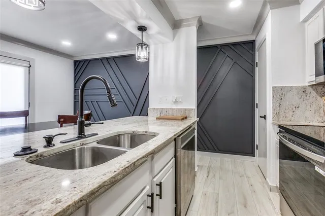 a kitchen with stainless steel appliances granite countertop a sink and a stove