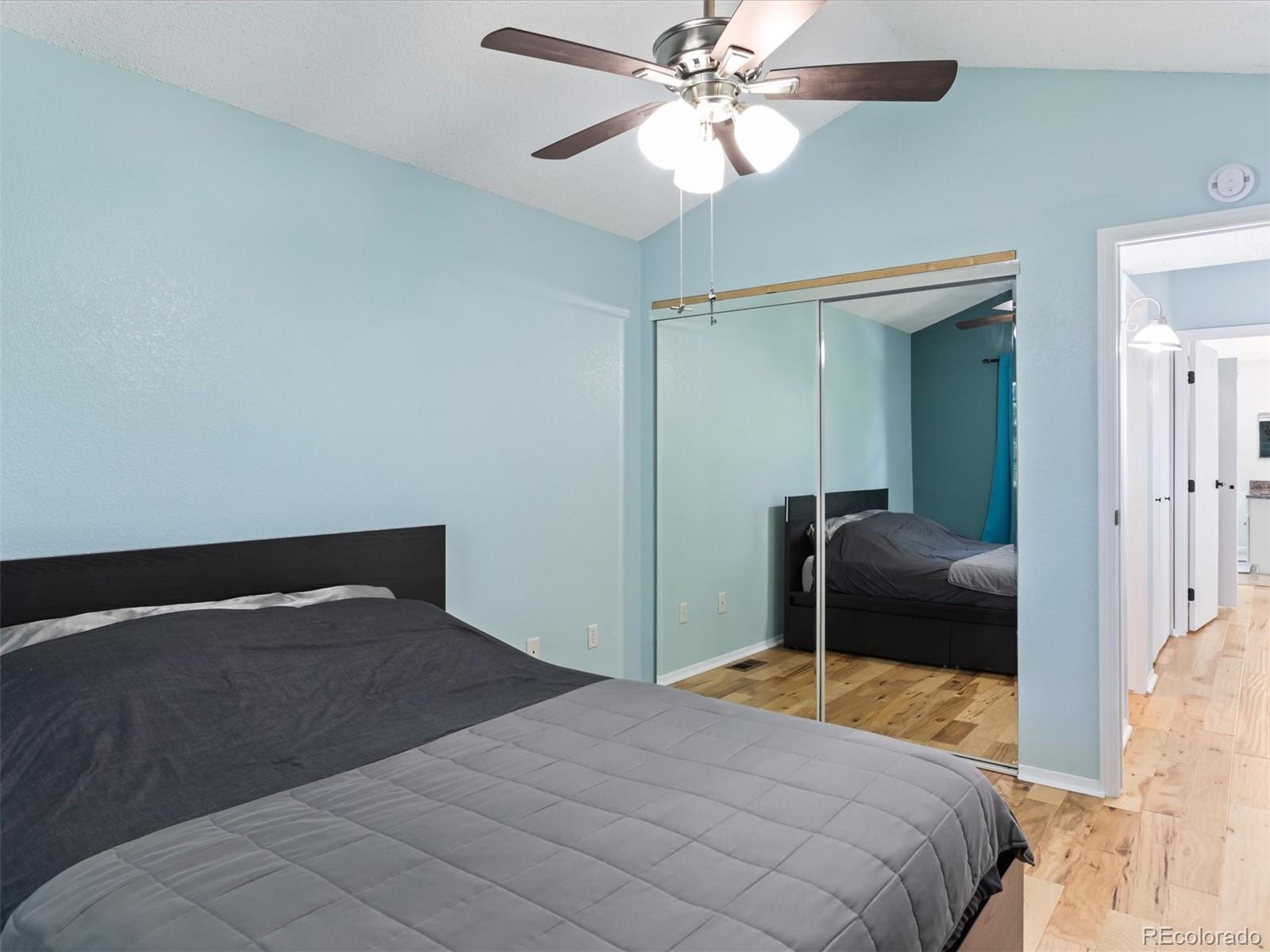 4301 South Pierce Street, Unit 2D Denver, CO 80123 - Photo 27 of 39 a bedroom with a bed and a chandelier