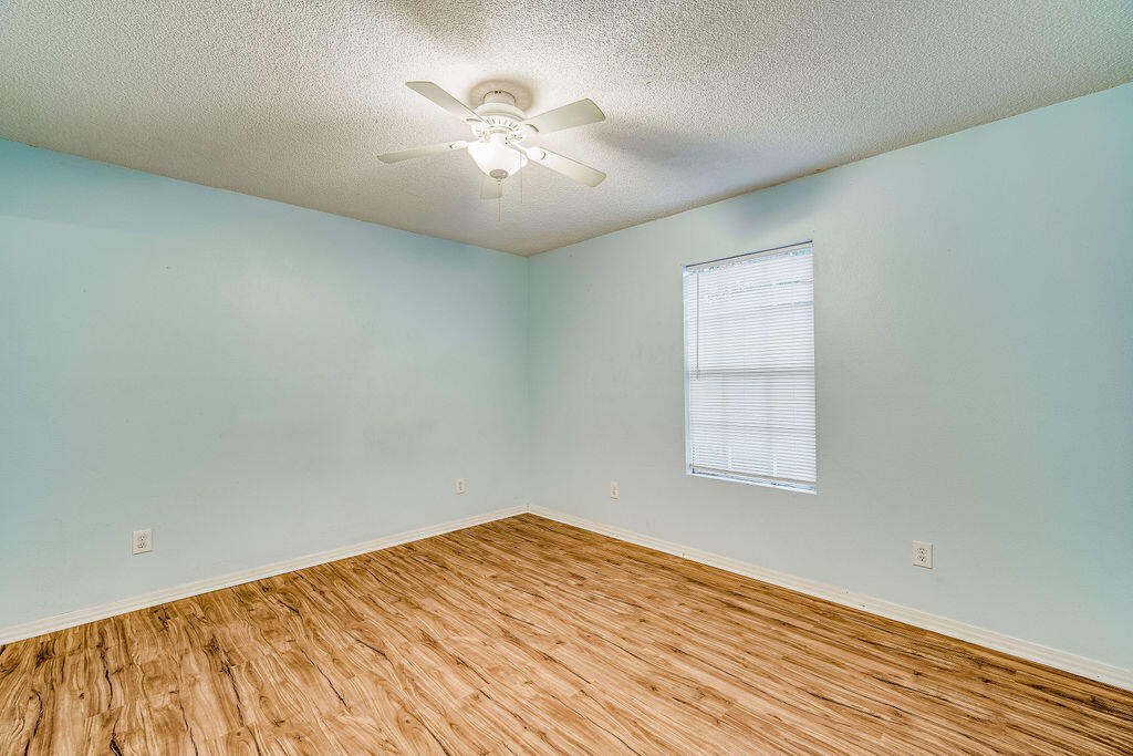 1003 Pinetree Road Mary Esther, FL 32569 - Photo 14 of 29 an empty room with a chandelier fan and windows