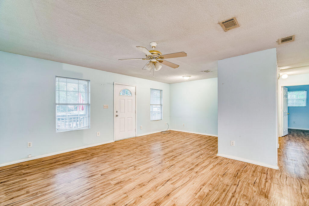 1003 Pinetree Road Mary Esther, FL 32569 - Photo 5 of 29 a view of an empty room with window and wooden floor