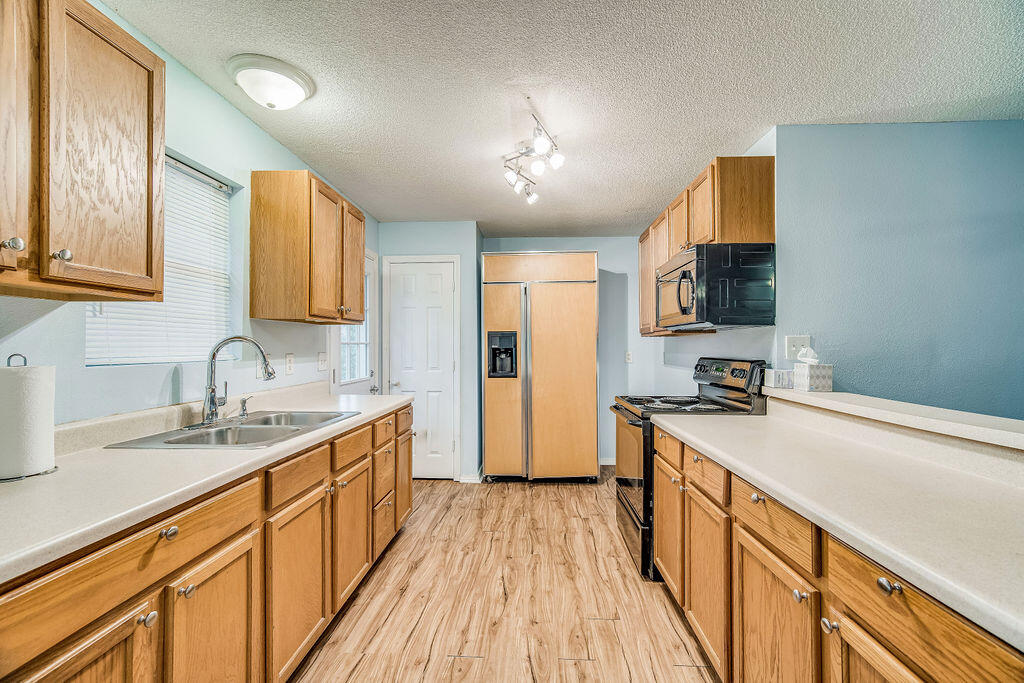 1003 Pinetree Road Mary Esther, FL 32569 - Photo 10 of 29 a kitchen with a sink a stove cabinets and a wooden floor