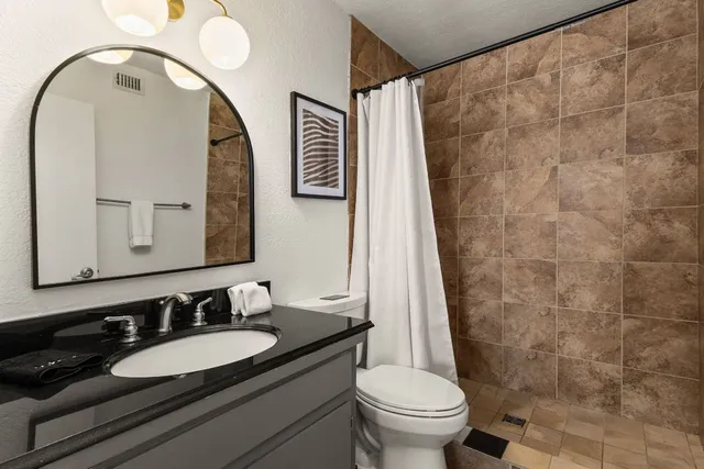a bathroom with a granite countertop sink and a mirror