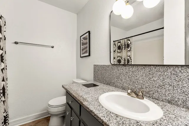 a bathroom with a granite countertop sink and a mirror