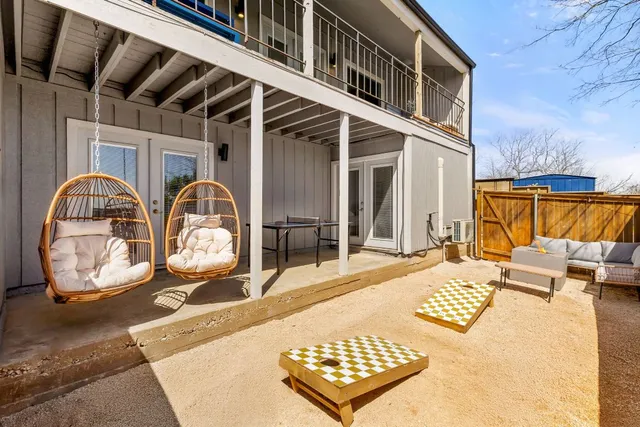 a backyard of a house with couches wooden floor and fence