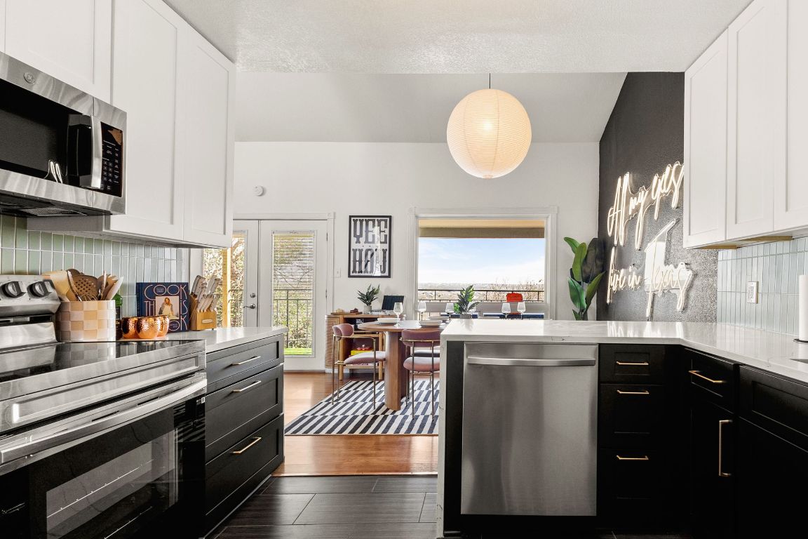 3306 Hyclimb Circle, Unit A Austin, TX 78723 - Photo 8 of 26 a kitchen with stainless steel appliances granite countertop a stove top oven a sink dishwasher and white cabinets with wooden floor