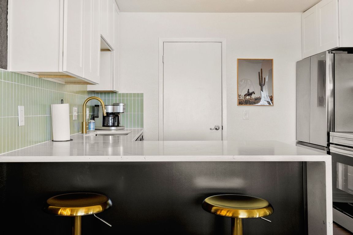 3306 Hyclimb Circle, Unit A Austin, TX 78723 - Photo 9 of 26 a kitchen with stainless steel appliances a table and chairs in it