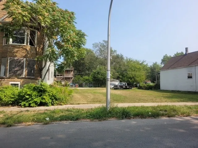 a view of a house with a yard and a street