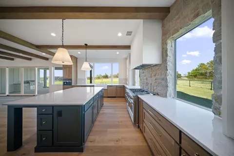 a kitchen with stainless steel appliances a stove and a wooden floor