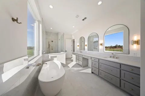 a spacious bathroom with a double vanity sink a mirror and a bathtub