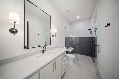 a bathroom with a sink a toilet and shower