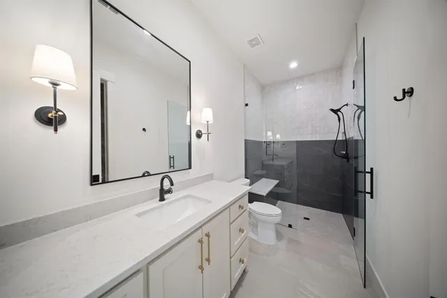 a bathroom with a sink a toilet and shower