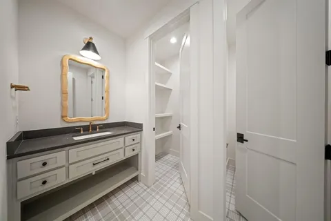 a spacious bathroom with a granite countertop sink and a mirror