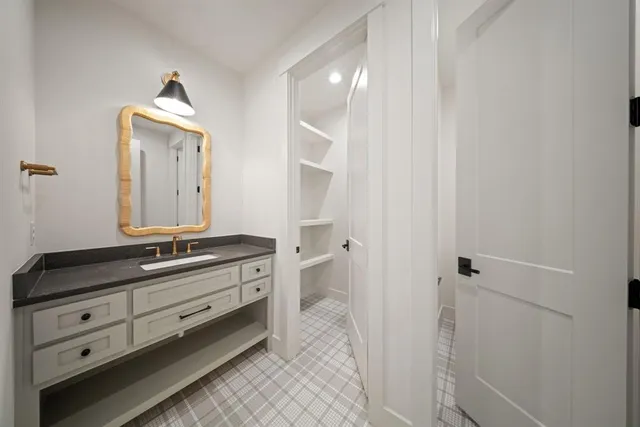 a spacious bathroom with a granite countertop sink and a mirror
