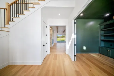 a view of a hallway with wooden floor and staircase