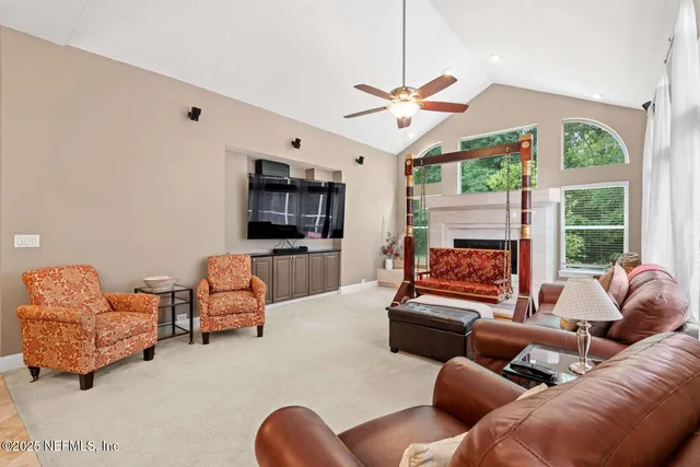 a living room with furniture flat screen tv and a large window