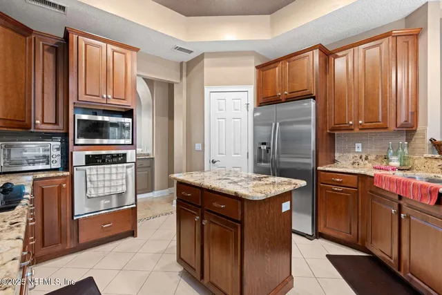 a kitchen with stainless steel appliances granite countertop a stove refrigerator and cabinets