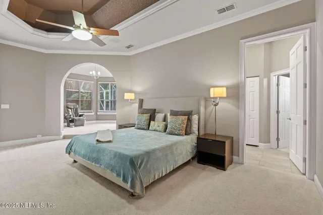 a bedroom with a bed and a large window