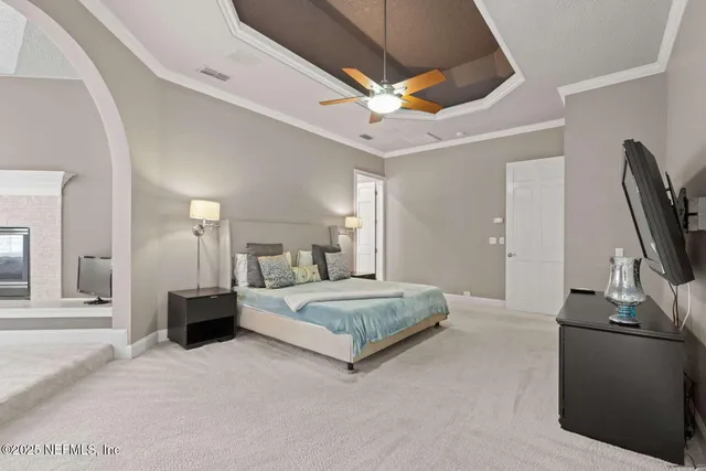 a spacious bedroom with a bed and a flat screen tv