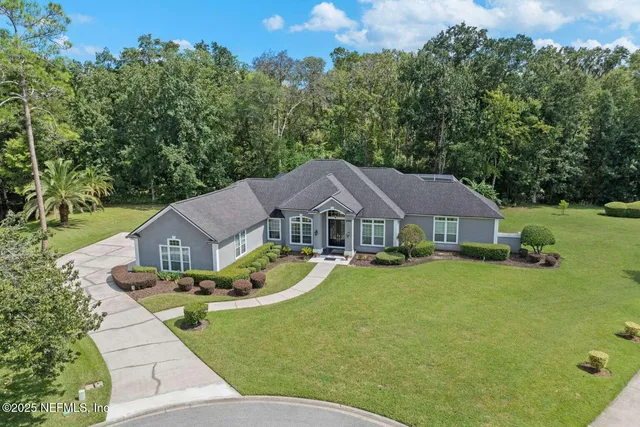 an aerial view of a house with a garden and lake view
