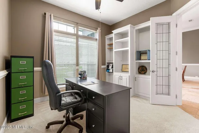 a view of a workspace with furniture and a window